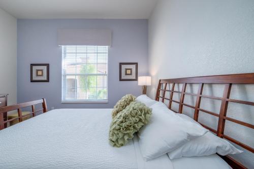 een slaapkamer met een groot bed met witte lakens en een raam bij New! Luxurious Vista Cay LakeView Penthouse Ciélo Near all Theme Parks, and walk to the Convention Center in Orlando