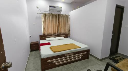 a bedroom with a bed in a white room at Backwaters Retreat in Ankola