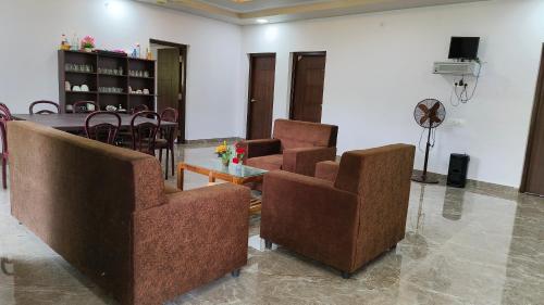 a living room with two chairs and a table at Backwaters Retreat in Ankola