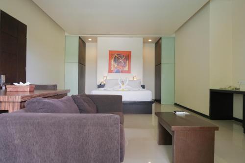 a living room with a couch and a bed at Sunset Mansion Seminyak in Seminyak