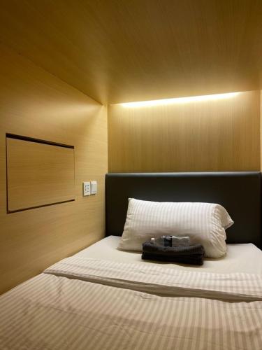 a bedroom with a bed with a large white pillow at Sogor Female Dormitory in George Town