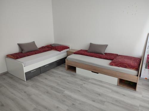 a room with two beds with red cushions at APARTMÁN ČAMBOR - na skok do prírody a mesta in Stupava