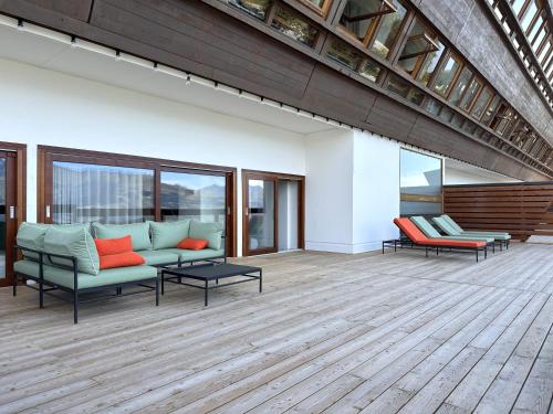 a living room with a couch and chairs on a wooden floor at La Cachette, Friendly Hotel & Spa in Arc 1600