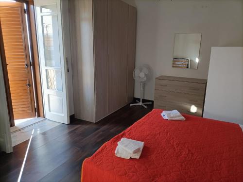 een slaapkamer met een rood bed en 2 handdoeken erop bij Casa d'Alunzio - Plesso Via Rebiba in San Marco dʼAlunzio