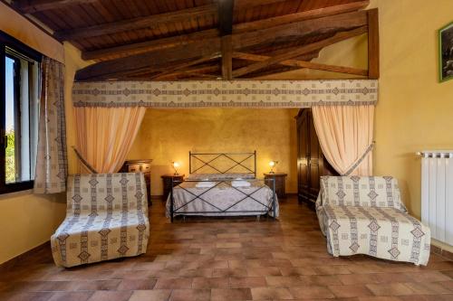 1 dormitorio con 2 camas y 2 sillas en Roccia, en Pitigliano