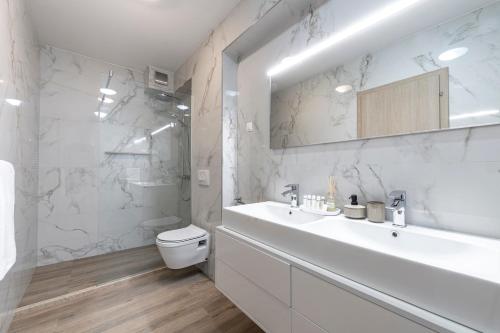 biała łazienka z umywalką i toaletą w obiekcie Villa Seraphina w mieście Zaton