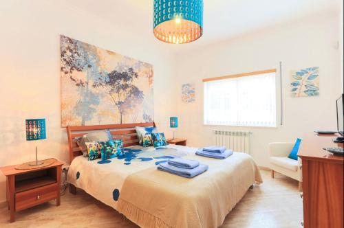 - une chambre avec un lit et des serviettes bleues dans l'établissement Rosa Villa, à Óbidos