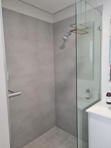 a shower with a glass door in a bathroom at 116 The Esplanade in Hermanus