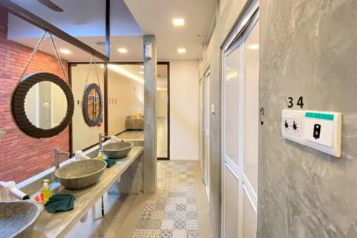 a bathroom with three sinks and a brick wall at Sogor Female Dormitory in George Town