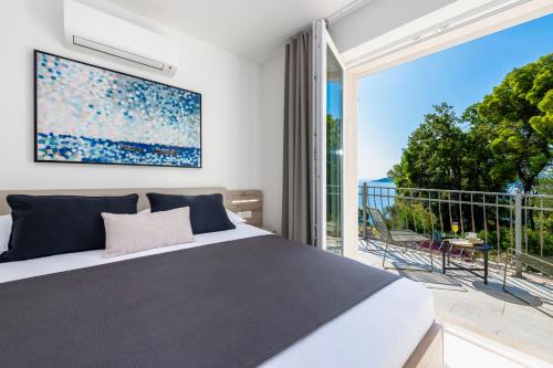 sypialnia z łóżkiem i dużym oknem w obiekcie Villa Seraphina w mieście Zaton