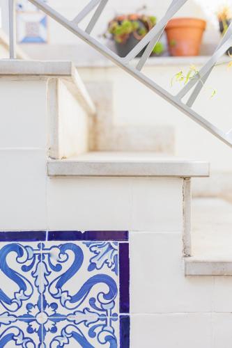 a staircase with blue and white tiles and a window at Lisbon Sunny Terrace Lapa Santos in Lisbon