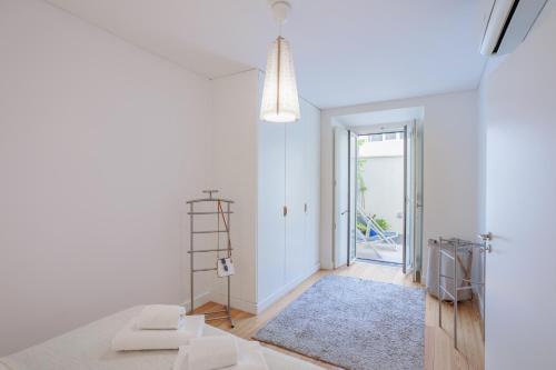 una sala de estar con paredes blancas y una escalera. en Lisbon Sunny Terrace Lapa Santos en Lisboa