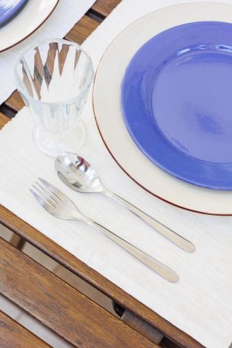 a table with a blue plate and silverware on it at Lisbon Sunny Terrace Lapa Santos in Lisbon