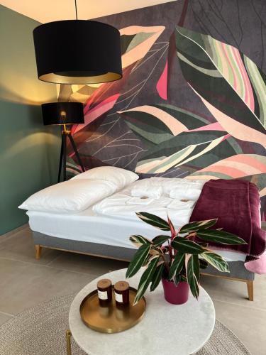 a bedroom with a bed and a table with a plant at BnB Open Apartments Pader-Lounge in Paderborn