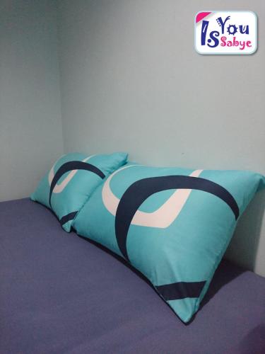 a bed with a blue comforter on top of it at IsYou Sabye ห้องพักรายวัน รามคำแหง in Ban Zong Katiam