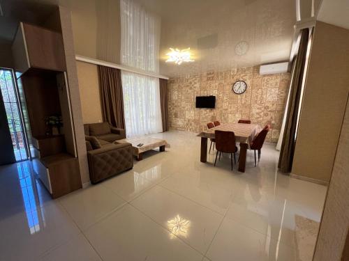 villa with beautiful view 3 في تبليسي: غرفة معيشة مع طاولة وأريكة