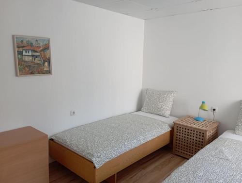 Gradina Apartment في مونتانا: غرفة نوم صغيرة مع سرير وموقف ليلي