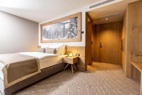 sypialnia z dużym łóżkiem i drewnianymi drzwiami w obiekcie Hotel Monti Spa & Wellness 