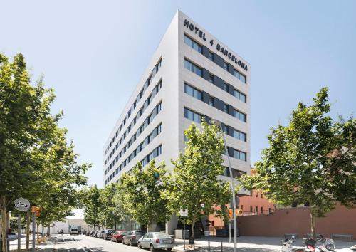 a tall white building with trees in front of a street at Hotel Best 4 Barcelona in Barcelona