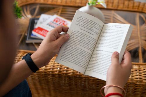 a person holding a book in their hands at Daisy by Wabi Sabi Stays with Private balcony in Rishīkesh