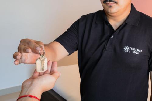a man handing a person a pair of keys at Daisy by Wabi Sabi Stays with Private balcony in Rishīkesh