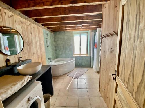 a bathroom with a tub and a sink and a mirror at Les Prés Grand Lodge in Montigné-le-Brillant