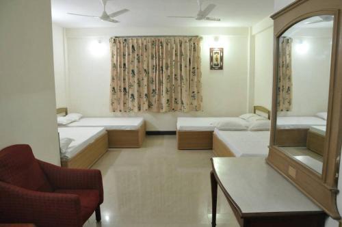 Habitación con 2 camas y espejo. en MYSORE MAHALAKSHMI ROOMS en Mysore