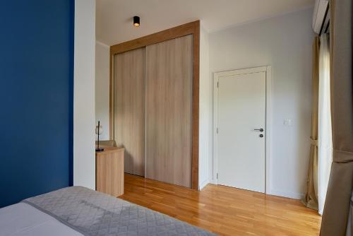 a bedroom with a door and a wooden floor at 2montenegro MIMOZA Apartments in Dobrota