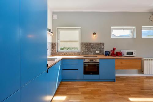 a kitchen with blue cabinets and a sink at 2montenegro MIMOZA Apartments in Dobrota