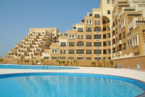 a large swimming pool in front of a building at Clarence Apartment in Ras al Khaimah