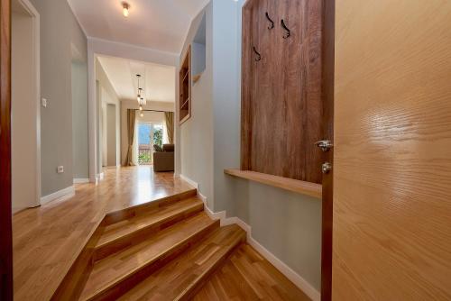 a hallway with a wooden door and wooden floors at 2montenegro MIMOZA Apartments in Dobrota