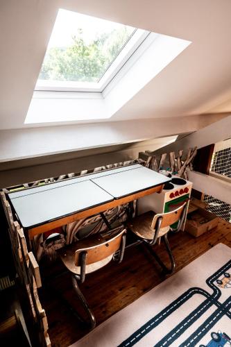 a table and chairs in a room with a skylight at L'arche De Noé in Dinant