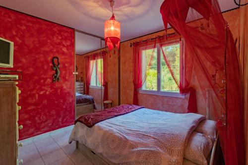 a red bedroom with a bed and a window at Petit coin de paradis Périgourdin in Montrem
