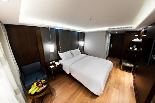 a bedroom with a white bed and a table with a bowl of fruit at ToBadaa - Nile cruise all inclusive from Aswan or Luxor 4 Days & 7 days in Aswan