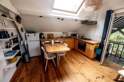 a kitchen with a wooden table and a refrigerator at L'arche De Noé in Dinant