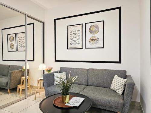 a living room with a couch and a table at Almas Suite by Nest Home【Puteri Harbour & LEGOLAND】 in Nusajaya