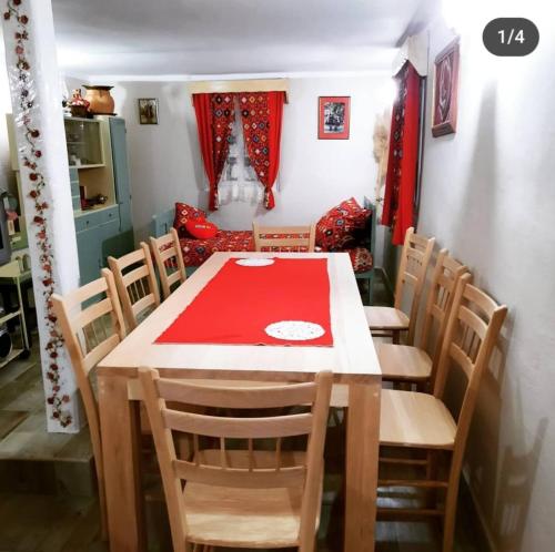 uma sala de jantar com uma mesa vermelha e cadeiras em Vikendica Nada em Ljubovija