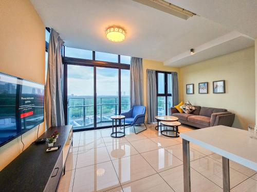 a living room with a couch and a large window at Almas Suite by Nest Home【Puteri Harbour & LEGOLAND】 in Nusajaya