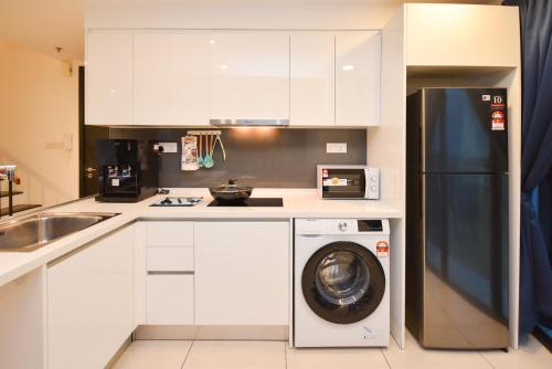 a kitchen with a refrigerator and a washing machine at Almas Suite by Nest Home【Puteri Harbour & LEGOLAND】 in Nusajaya