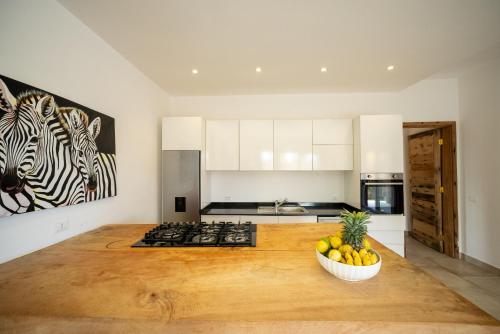 a kitchen with a counter with a bowl of fruit at SandBank View Villa - Private Pool- ZanzibarHouses in Kiwengwa