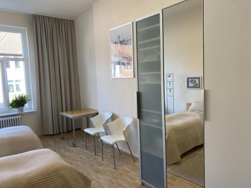 - une chambre avec 2 lits, une table et des chaises dans l'établissement Zweibettzimmer Business mit eigenem Bad ( Nichtraucher ), à Hanovre