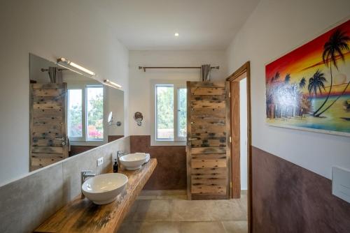 baño con 2 lavabos y una gran pintura en la pared en SandBank View Villa - Private Pool- ZanzibarHouses, en Kiwengwa