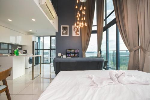 a bedroom with a white bed and a kitchen at Almas Suite by Nest Home【Puteri Harbour & LEGOLAND】 in Nusajaya