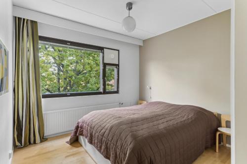 a bedroom with a bed and a large window at Happy Home Lauttasaari in Helsinki