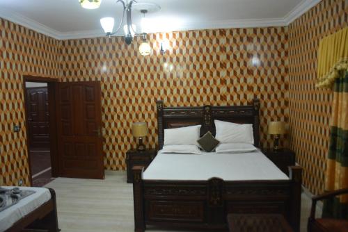 a bedroom with a bed in a room with wallpaper at Sardar House, Dunga Gali in Dunga Gali