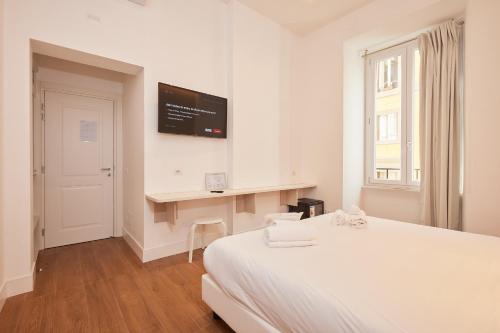 a white bedroom with a bed and a desk at DEM Hotel in Rome