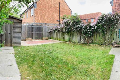 un patio con una valla y un patio con césped en Aidan House by Blue Skies Stays en Middlesbrough