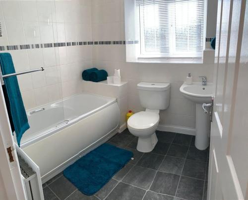 y baño con bañera, aseo y lavamanos. en Aidan House by Blue Skies Stays en Middlesbrough