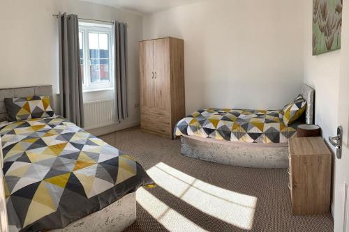 1 dormitorio con 2 camas y ventana en Aidan House by Blue Skies Stays en Middlesbrough