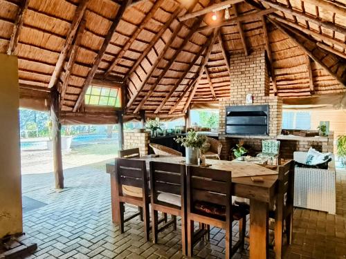 a kitchen with a wooden table and chairs at La Bohéme Gastehuis in Bloemfontein